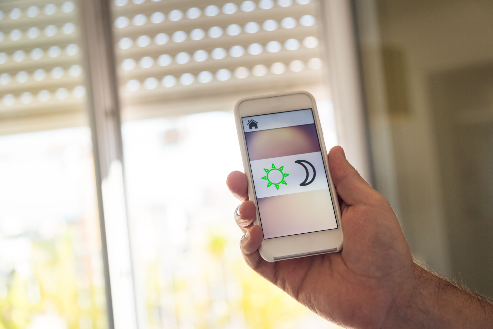 Smart home: man controlling blinds with app on his phone